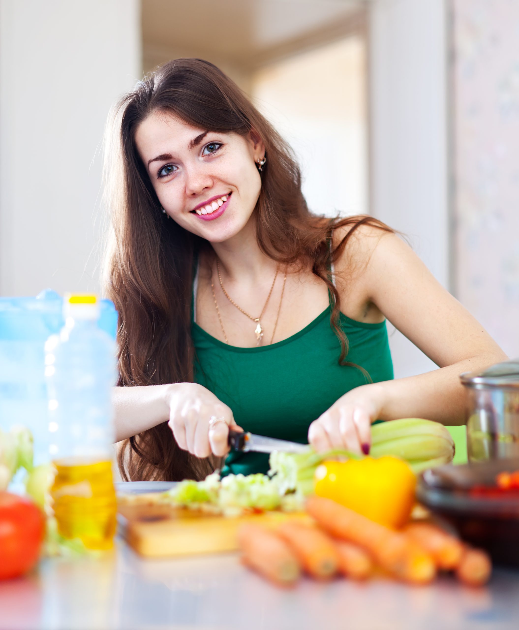 happy woman cutting vegetables scaled